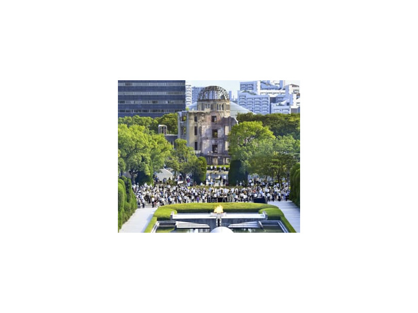 昨年8月6日、広島市の平和記念公園で黙とうする人たち。後方は原爆ドーム