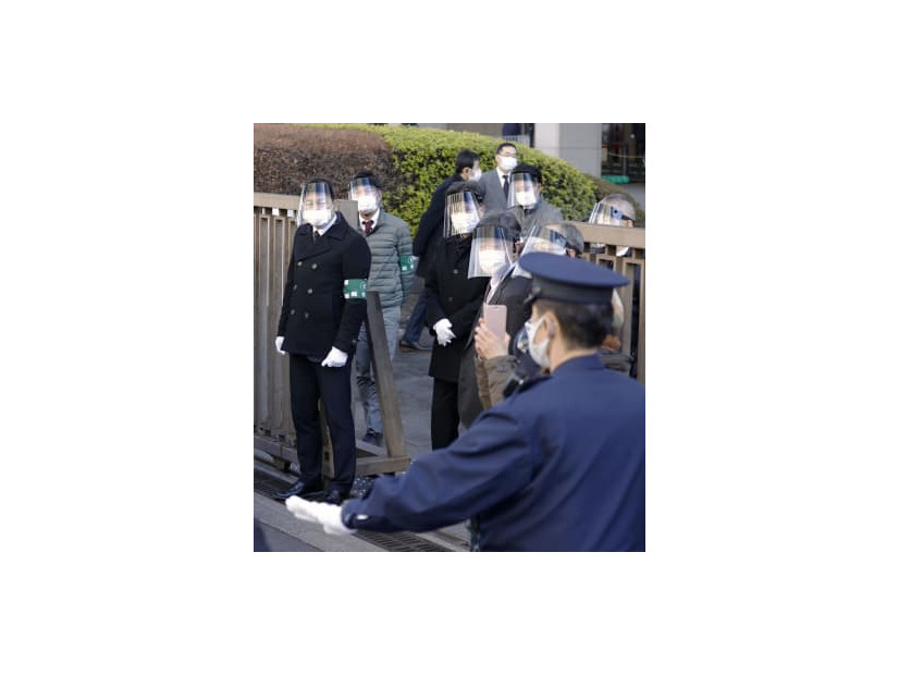 新型コロナウイルスのワクチン特例承認取り消し訴訟で、フェースガードとマスクを着けて東京地裁前で警戒する裁判所職員＝13日午前