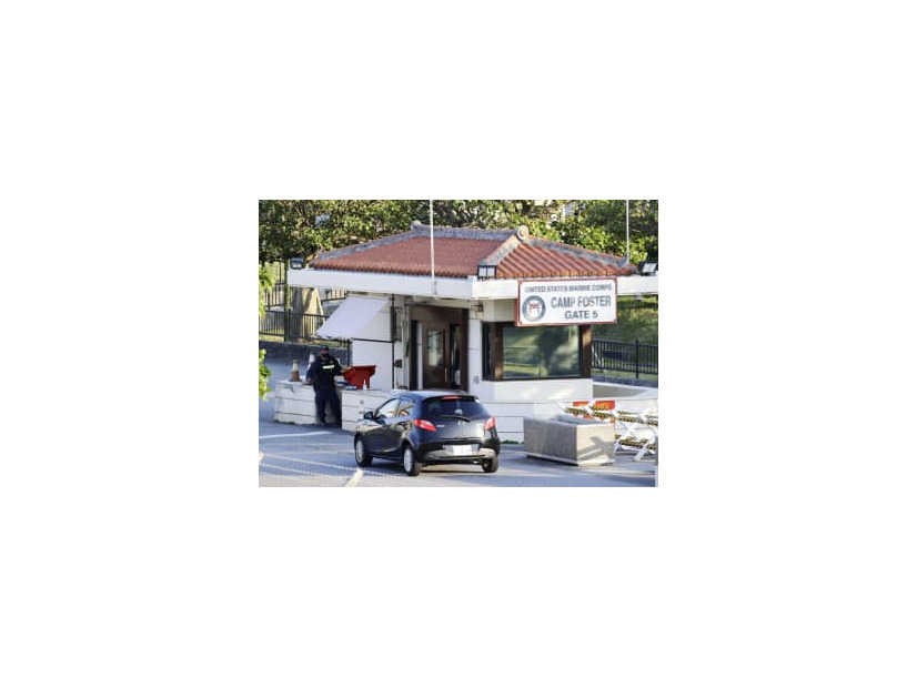 9日、沖縄県北谷町の米軍キャンプ・フォスターのゲート前で車両のチェックをする関係者