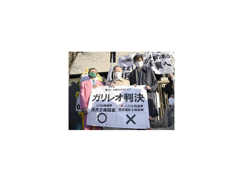 衆院選の「1票の格差」訴訟の判決を受け、東京高裁前で「ガリレオ判決」と書かれた紙を掲げる升永英俊弁護士（中央）ら＝2日午後