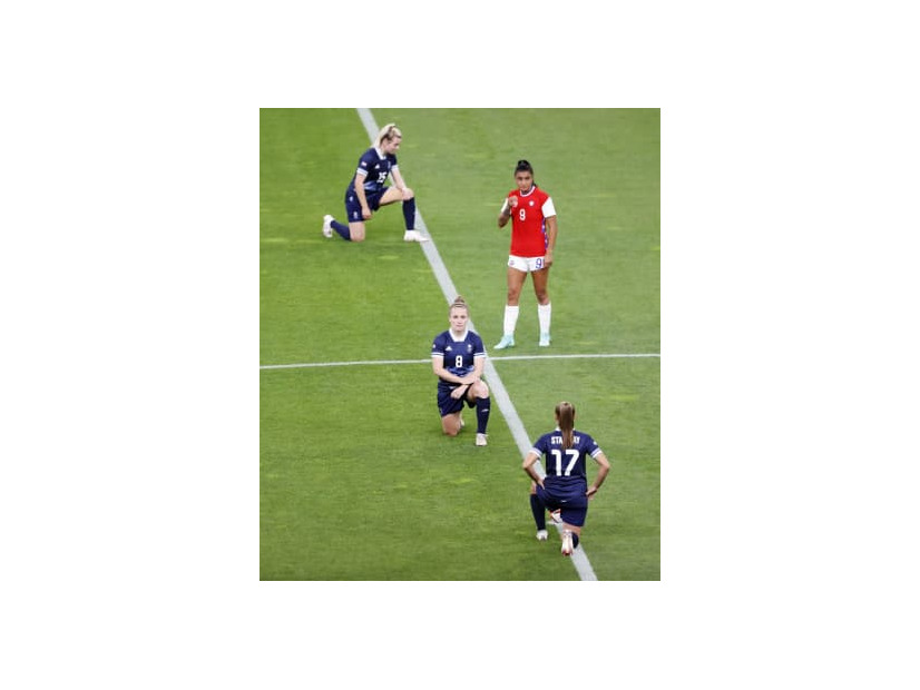 東京五輪サッカー女子の試合前のピッチで、人種差別に抗議し片膝をつく英国代表の選手ら＝2021年7月、札幌ドーム