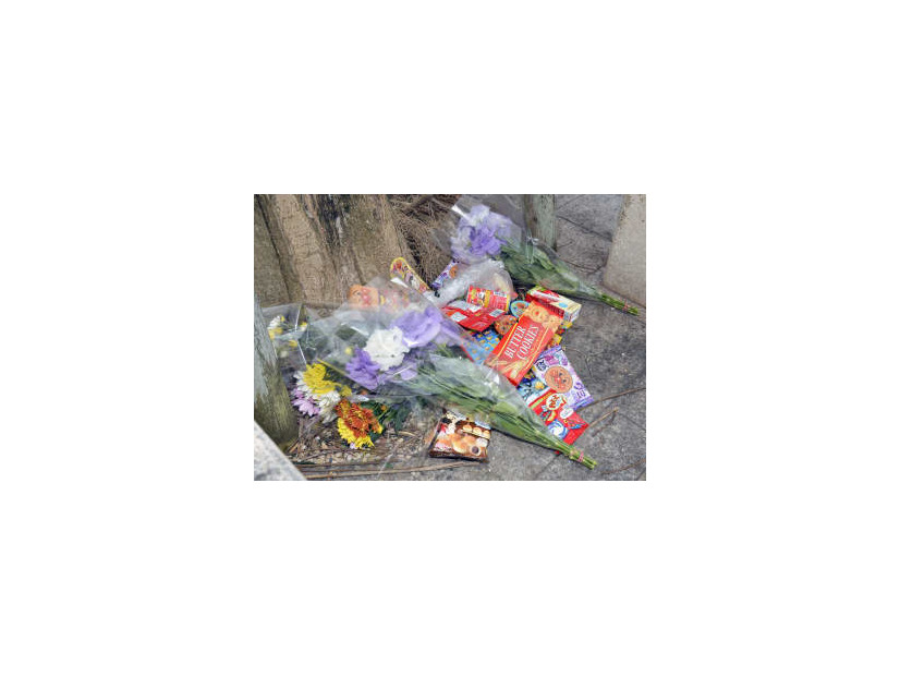 女児がベランダから転落死した市営住宅に手向けられた花束や菓子＝9日午前、沖縄県名護市