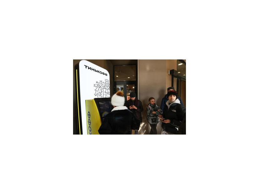 現金自動預払機（ATM）から現金を引き出すために並ぶ人たち＝2日、モスクワ（タス＝共同）