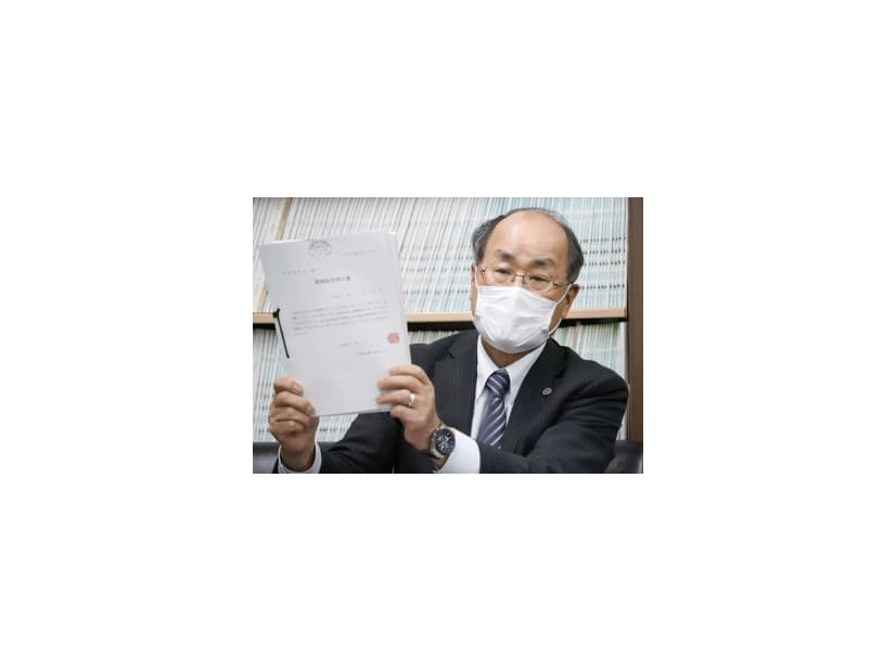 名張毒ぶどう酒事件で、特別抗告の申立書を手に記者会見する鈴木泉弁護団長＝9日午後、名古屋市