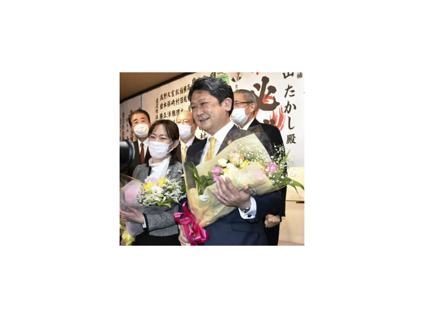 金沢市長選で初当選し、花束を手に笑顔を見せる村山卓氏（手前右）＝13日夜