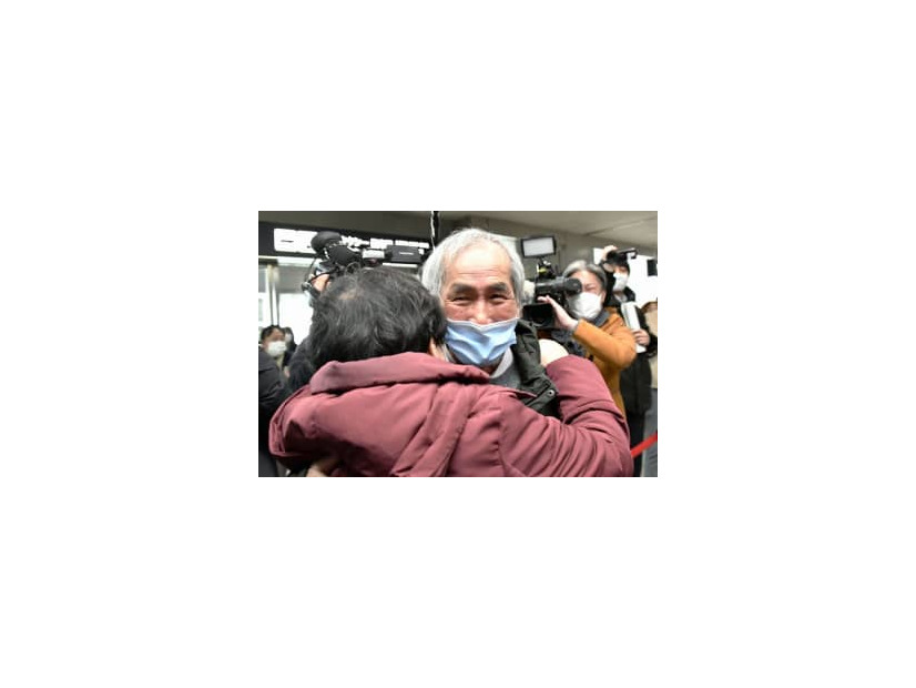 旭川空港に到着し、妹婦美子さん（手前）と抱き合う降籏英捷さん＝20日午後