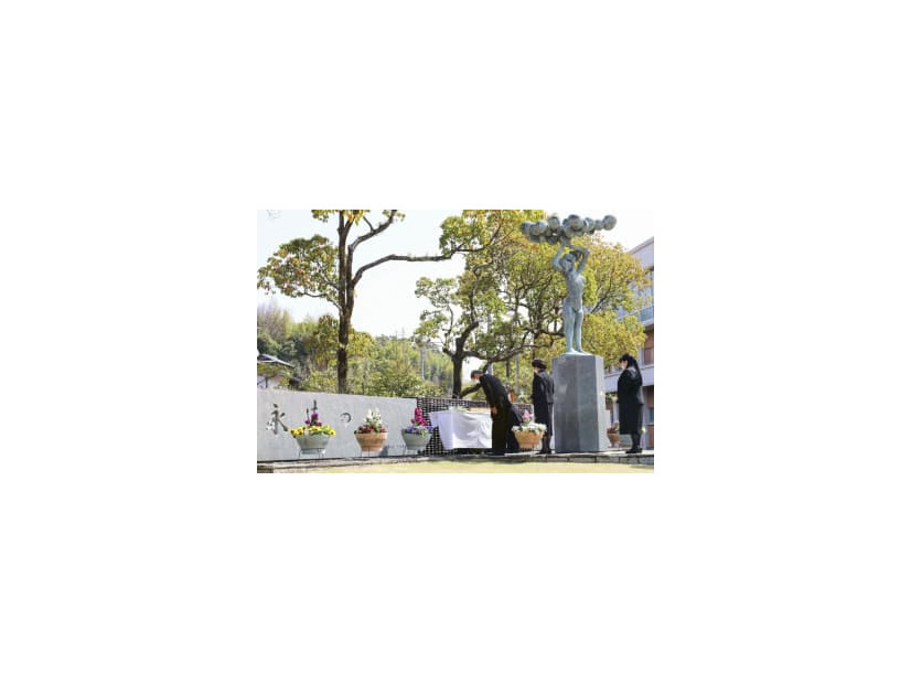 私立高知学芸高で営まれた上海列車事故の慰霊式で献花する遺族ら＝24日午前、高知市