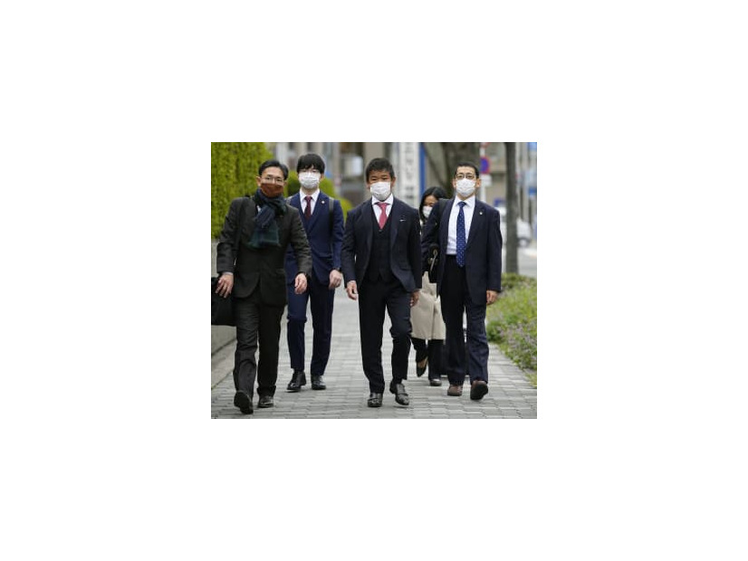提訴のため、大阪地裁に向かうプレサンスコーポレーションの山岸忍前社長（中央）ら＝29日午前