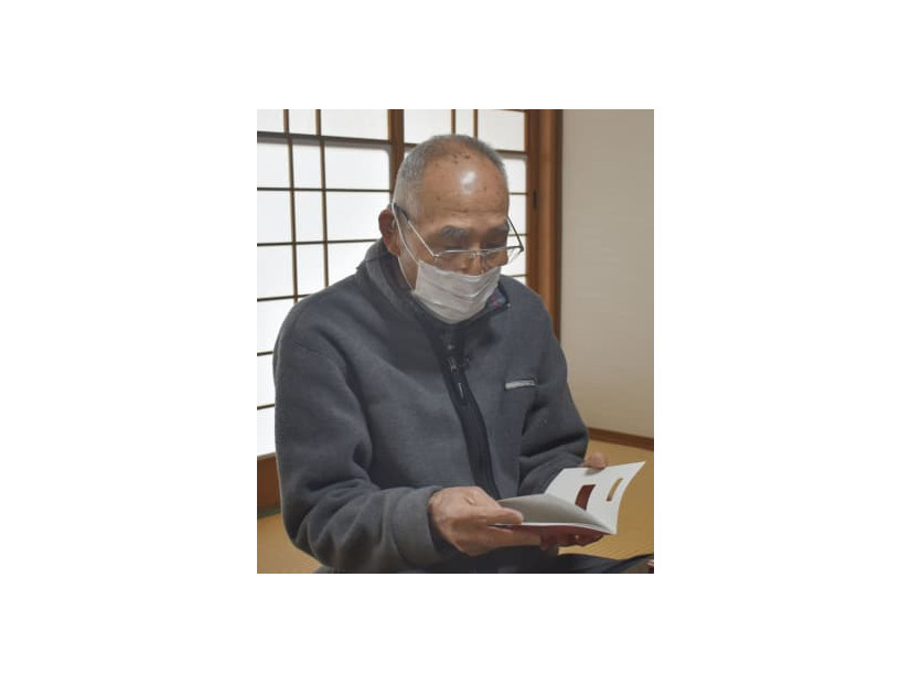 被爆者健康手帳を見る斉藤修吾さん＝1日午後、広島市