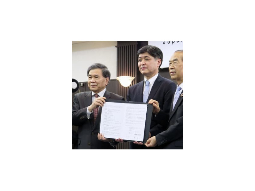 立地協定を結び、記念撮影に応じる「JASM」の堀田祐一社長（中央）ら＝19日午後、熊本市