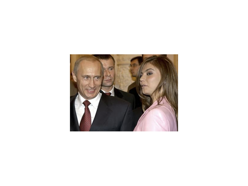 アリーナ・カバエワさん（右）の隣で笑顔を見せるロシアのプーチン大統領＝2004年11月、モスクワのクレムリン（ロイター＝共同）