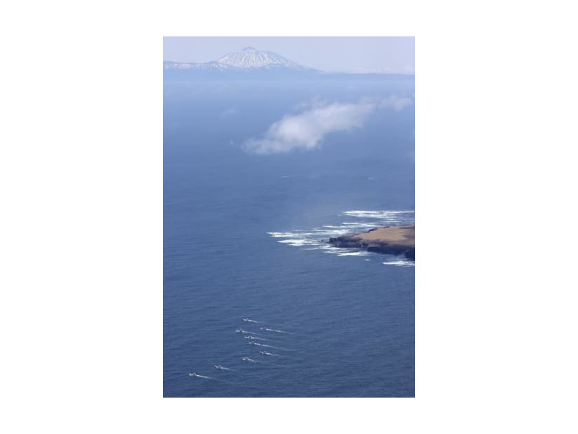 4月30日、北海道・知床半島沖で捜索する漁船団（左下）。奥は国後島（共同通信社ヘリから）