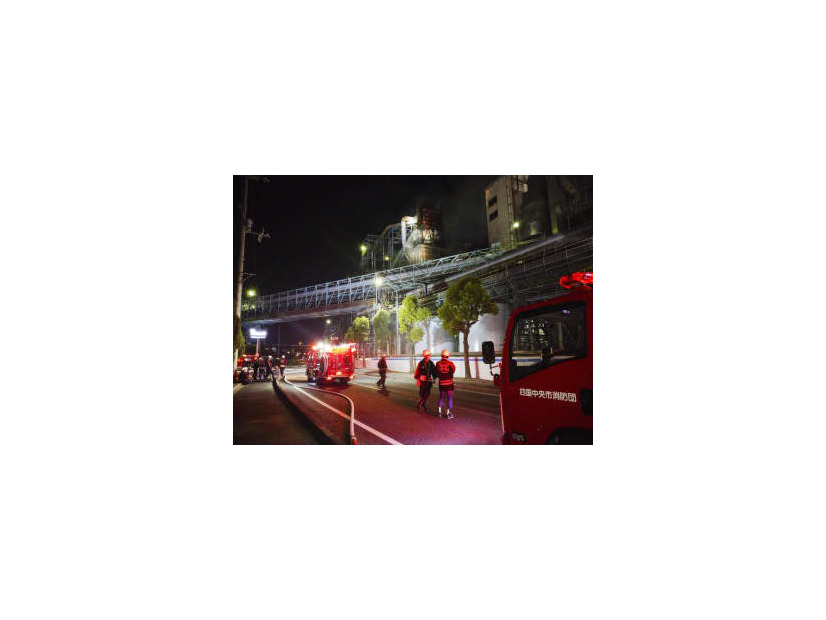 火災が発生した大王製紙三島工場で消火活動する消防団員ら＝23日夜、愛媛県四国中央市