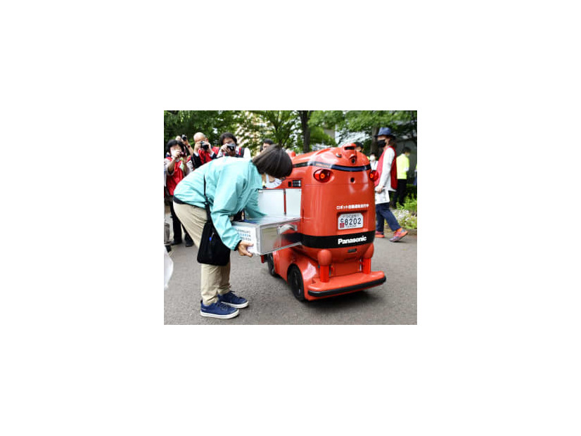 商品を積み込まれる自動配送ロボット＝26日、茨城県つくば市