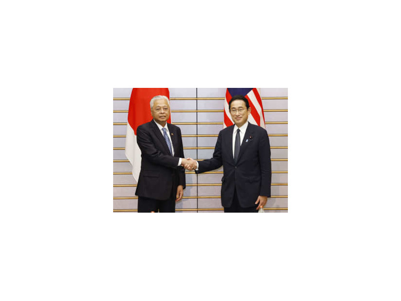 会談を前に握手するマレーシアのイスマイルサブリ首相（左）と岸田首相＝27日午後、首相官邸