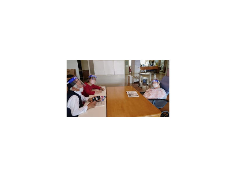 鹿児島県内の病院で鴨志田祐美弁護士（左奥）らと面会する原口アヤ子さん（右）＝4月（大崎事件弁護団提供）