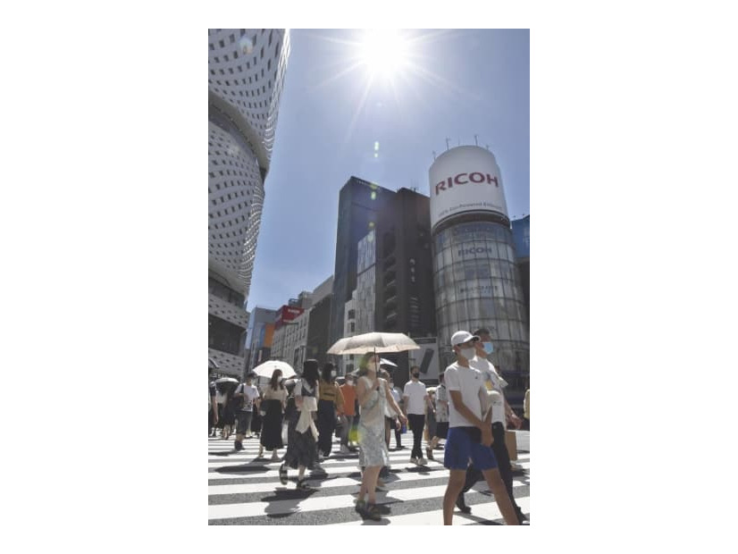 強い日差しが照りつける中、東京・銀座を歩く買い物客ら＝21年7月