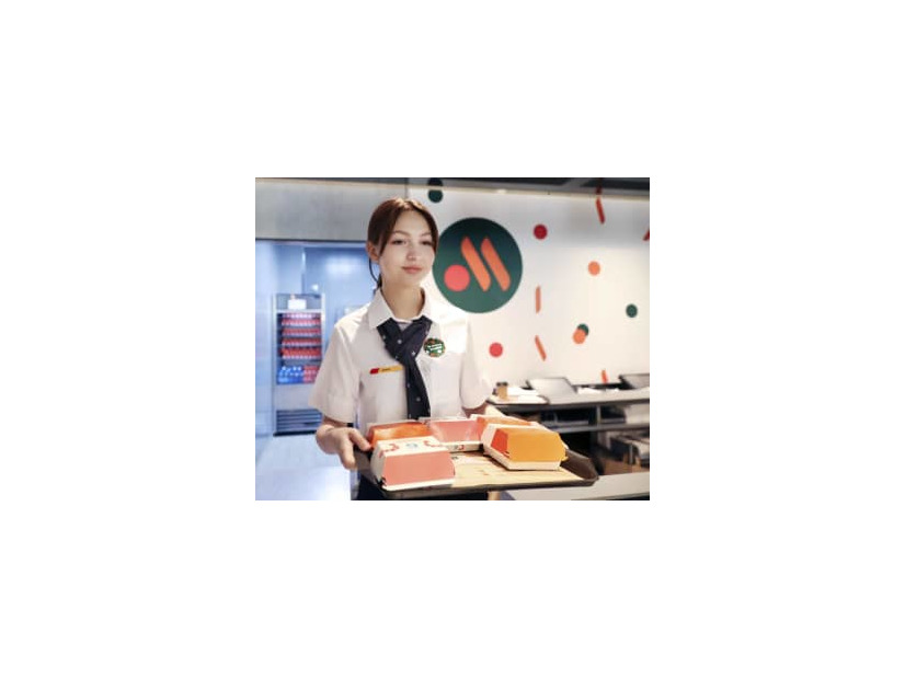 12日、モスクワ中心部で営業を開始した米マクドナルドの後継店「フクースナ・イ・トーチカ」で商品を運ぶ店員（タス＝共同）