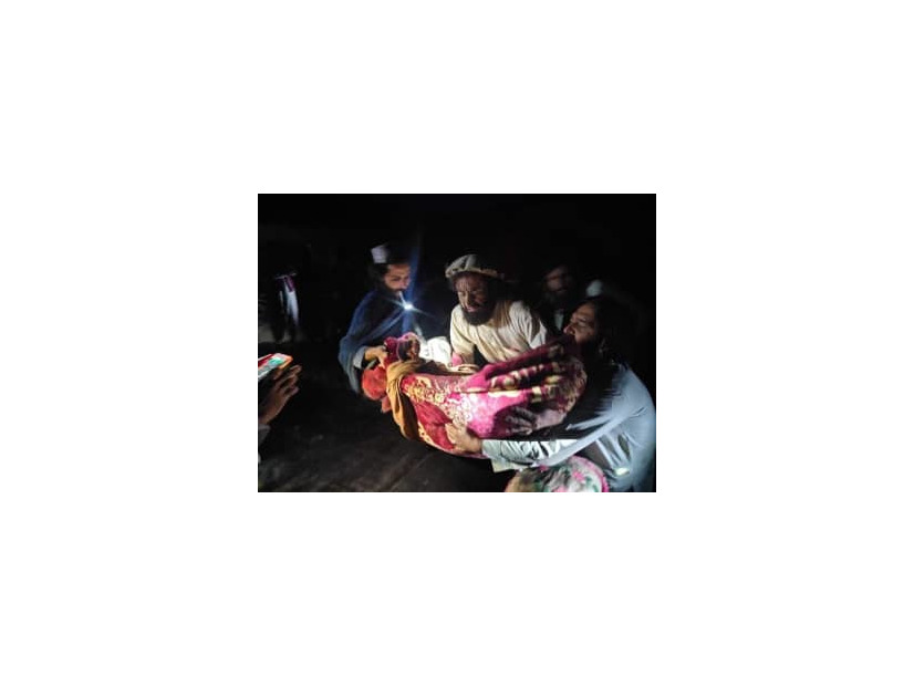 22日、アフガニスタン東部パクティカ州で、地震の負傷者を避難させる人々（Bakhtar　News　Agency提供、AP＝共同）