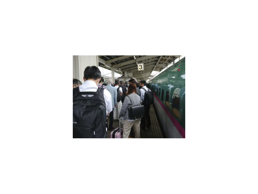 東北新幹線（右）が停車し、白石蔵王駅で後続の列車に乗り換える人たち＝23日午前11時51分、宮城県白石市