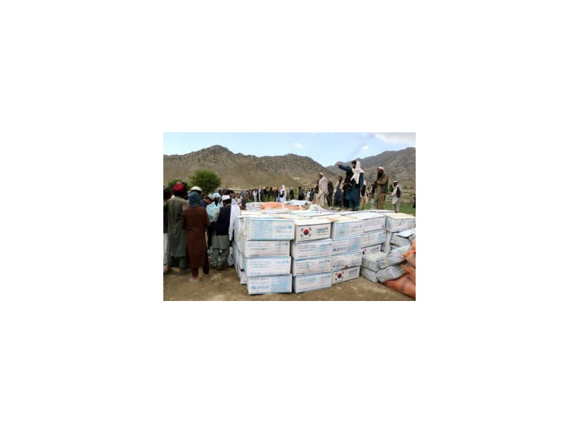支援物資を受け取るため、集まる被災者ら＝23日、アフガニスタン東部（ロイター＝共同）