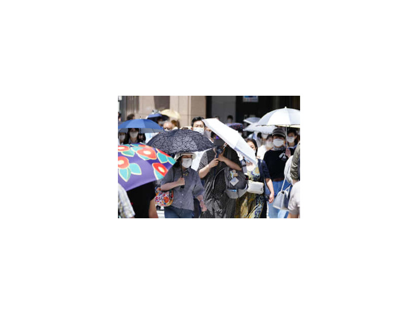 猛烈な暑さの中、日傘を差して歩く人たち＝26日午後、東京・銀座