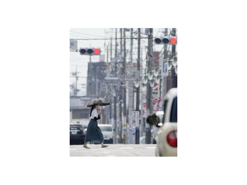 梅雨明けしたとみられる栃木県佐野市で、猛暑の中を歩く女性＝27日午後