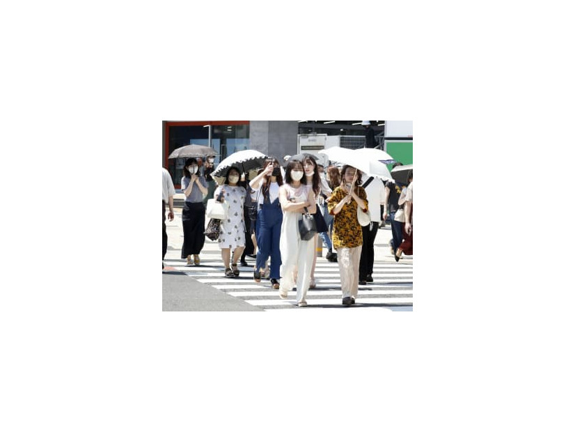 猛暑の中、東京・表参道を歩く人たち＝30日午後
