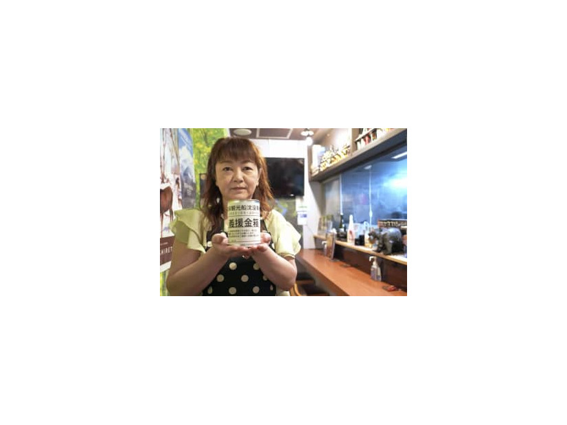 募金箱を持つ「知床小さな居酒屋　まりの店」店主の工藤真理子さん＝6月24日、札幌市