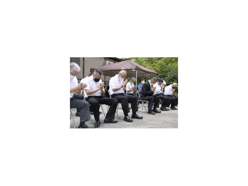 旅館経営の一家4人を追悼する式典で手を合わせる人たち＝7日午前、大分県由布市