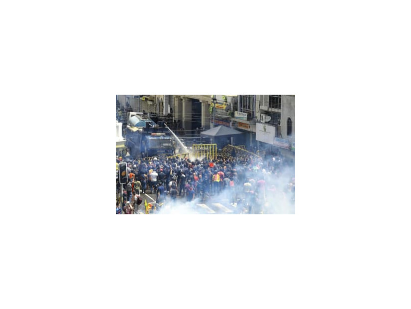 9日、スリランカ・コロンボで、放水砲や催涙ガスを使いデモ隊の鎮圧に当たる警察（AP＝共同）