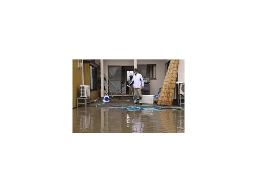 大雨の影響で浸水した自宅の掃除をする男性。家屋は床上1メートルまで水に漬かり、冷蔵庫やテレビなどの家電製品が壊れたという。「この7年で3回目の被害。堤防をしっかりと整備してほしい」と訴えた＝17日午前、宮城県大崎市