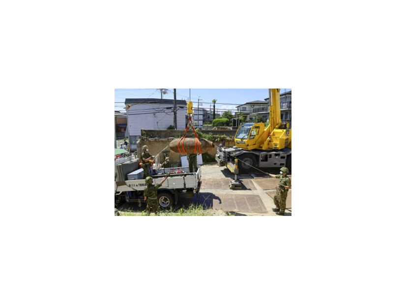 信管が取り除かれた不発弾をトラックに積み込む陸上自衛隊員ら＝24日午後、大阪府吹田市