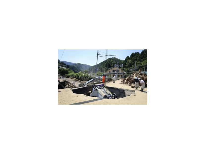 道路の陥没部分から引き上げられる車＝8日、福井県南越前町