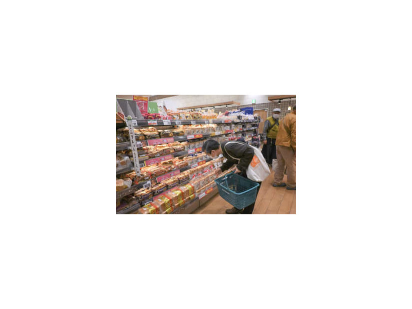 スーパーで商品のパンを見る男性＝5月、東京都大田区
