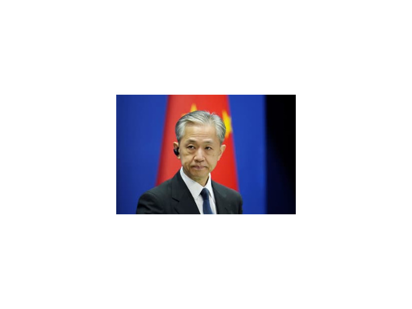 記者会見する中国外務省の汪文斌副報道局長＝18日、北京（共同）