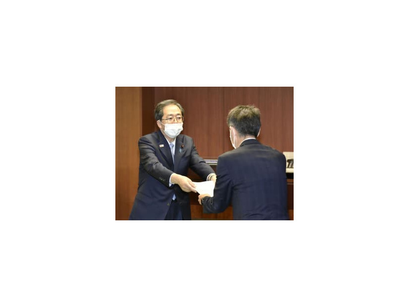 日野自動車の小木曽聡社長（右）に是正命令書を手渡す斉藤国交相＝9日午後、国交省