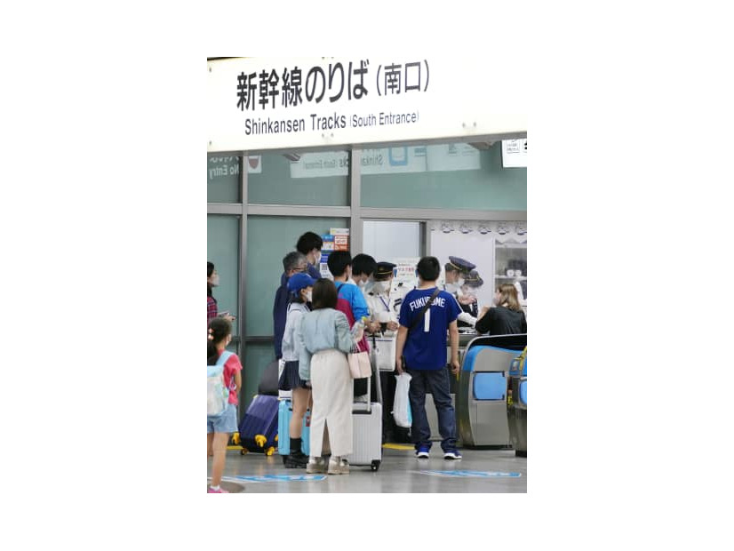 降雨のため東海道新幹線の運転が中止となり、対応に追われる駅員ら＝23日午後11時43分、JR名古屋駅