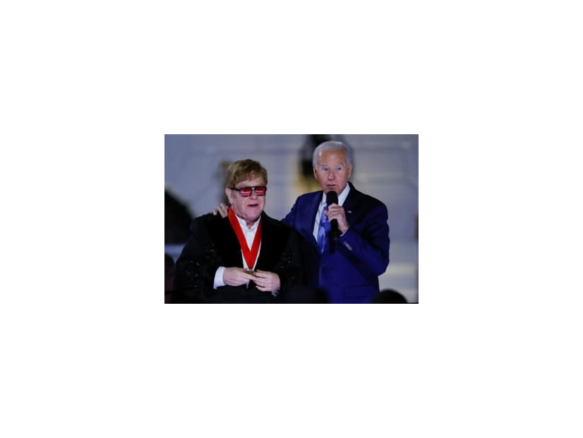 23日、米ホワイトハウスで、バイデン大統領からメダルを授与される英歌手エルトン・ジョンさん（ロイター＝共同）