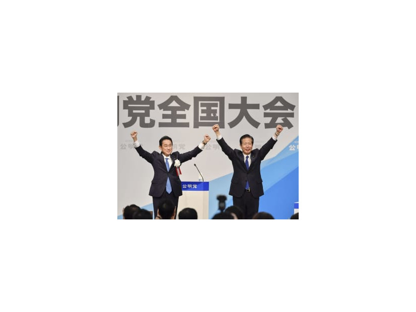 公明党の党大会で来賓あいさつを終え、山口代表（右）と両手を上げる岸田首相＝25日午後、東京都内のホテル