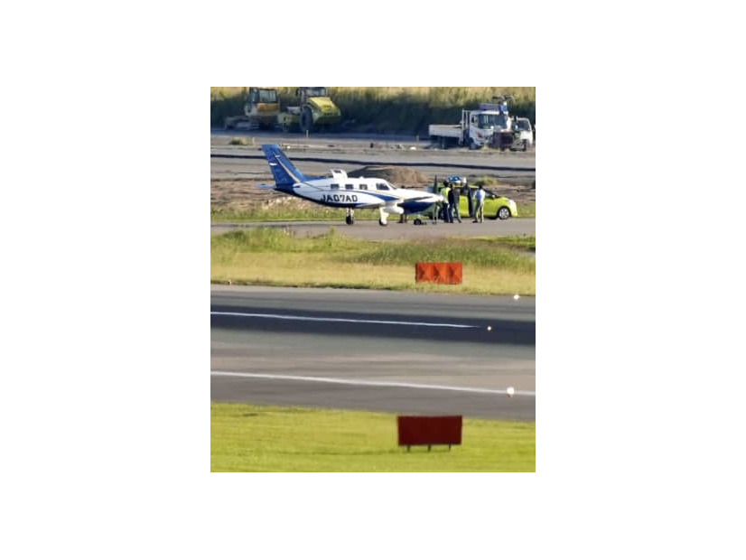 誘導路上でパンクした小型航空機。手前は福岡空港の滑走路＝20日午後4時37分