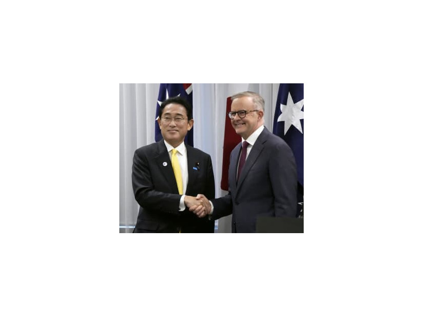共同記者発表を終え、オーストラリアのアルバニージー首相（右）と握手する岸田首相＝22日、パース（共同）