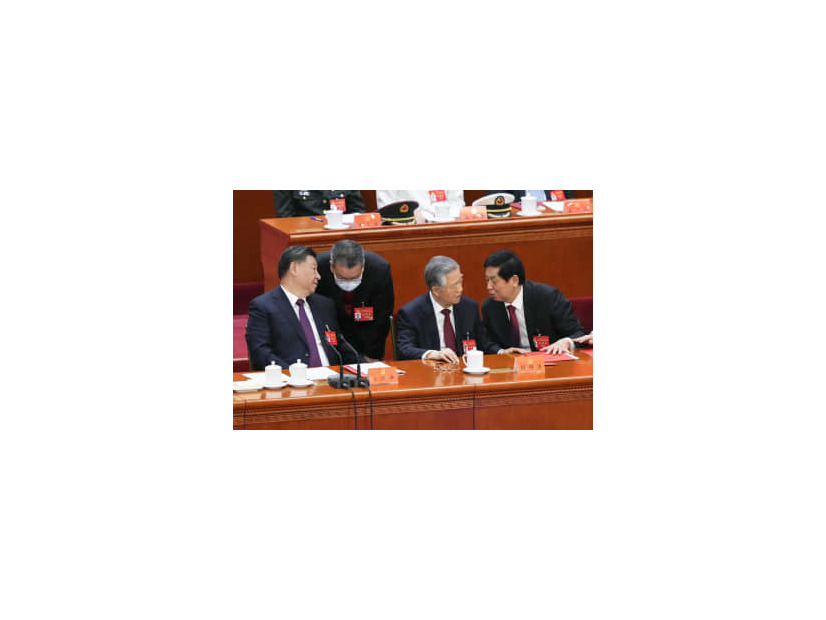 第20回中国共産党大会の閉幕式で、胡錦濤前総書記（右から2人目）の書類を手で押さえる栗戦書氏。左端は習近平総書記＝22日、北京の人民大会堂（共同）