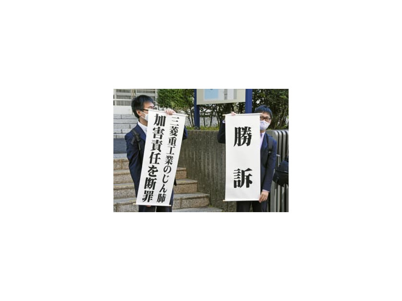 判決後に「勝訴」などと書かれた垂れ幕を掲げる原告側弁護士＝7日午前、長崎地裁前