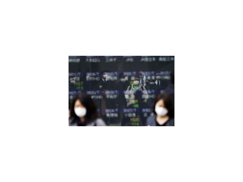 13日、東京都内の株価ボードに反射して写る、マスク姿の人たち（AP＝共同）
