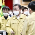 25日、韓国・大邱で開かれた新型コロナウイルスの対策会議に出席する文在寅大統領（中央）（聯合＝共同）