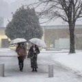 雪が降る金沢市内を歩く人たち＝13日午後4時43分
