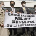 臨時国会召集訴訟の控訴審判決後に、「内閣に続いて裁判所も憲法無視」などと書かれた横断幕を掲げる原告側の弁護士ら＝27日午後、岡山市