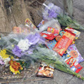 女児がベランダから転落死した市営住宅に手向けられた花束や菓子＝9日午前、沖縄県名護市