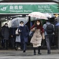 JR新橋駅前を傘を差して歩く人たち。関東甲信を中心に大雪が降る恐れがある＝10日午前